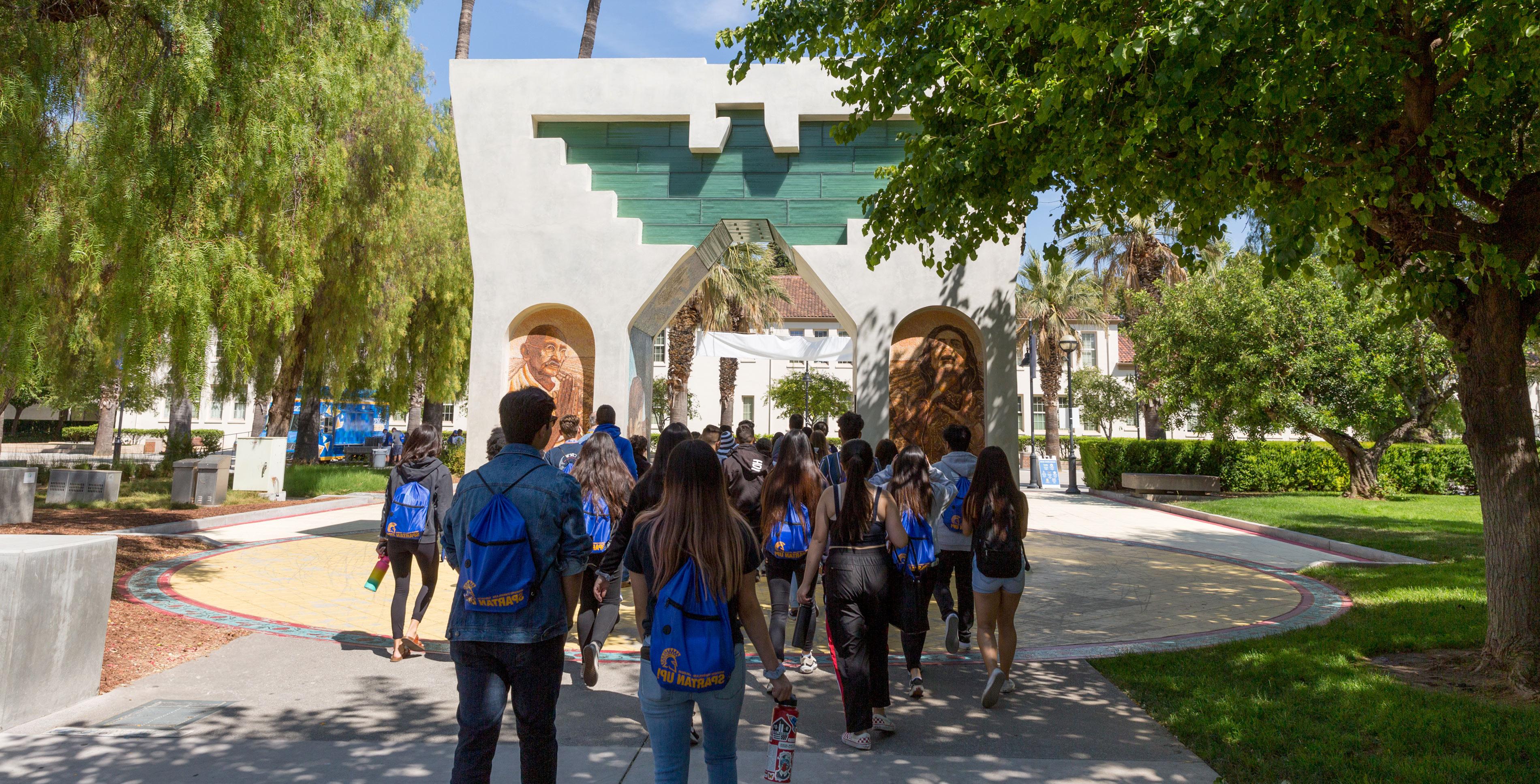 Students walking through the Cesar Chavez monument on the 菠菜网lol正规平台 campus.